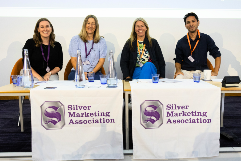 Hil Mines from walking for charity app trundl is sitting smiling alongside other founders in the Silver Marketing conference